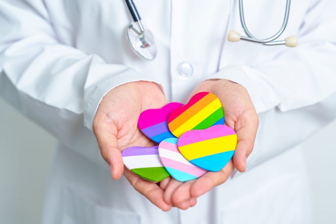 Doctor holding LGBTQ heart stickers